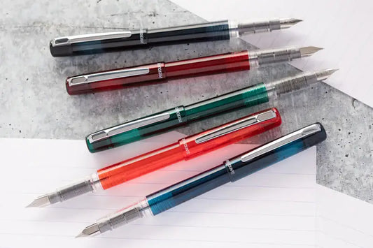 Set of five multicolored pens on a textured surface