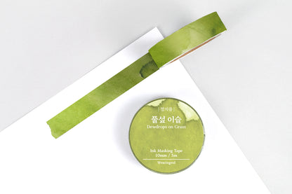 Green masking tape roll and strip on a white background
