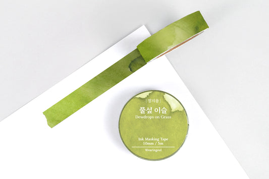 Green masking tape roll and strip on a white background